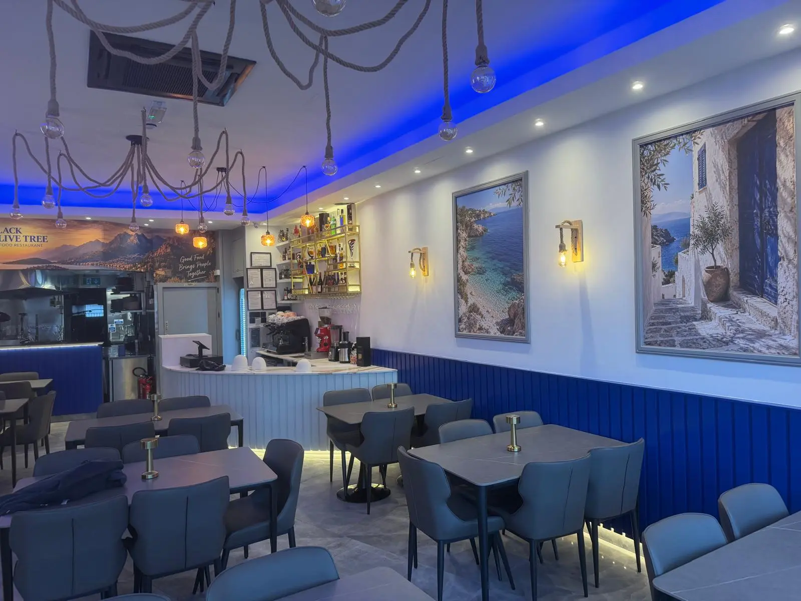 Inside Black Olive Tree — blue banquettes, pendant lights and the bar