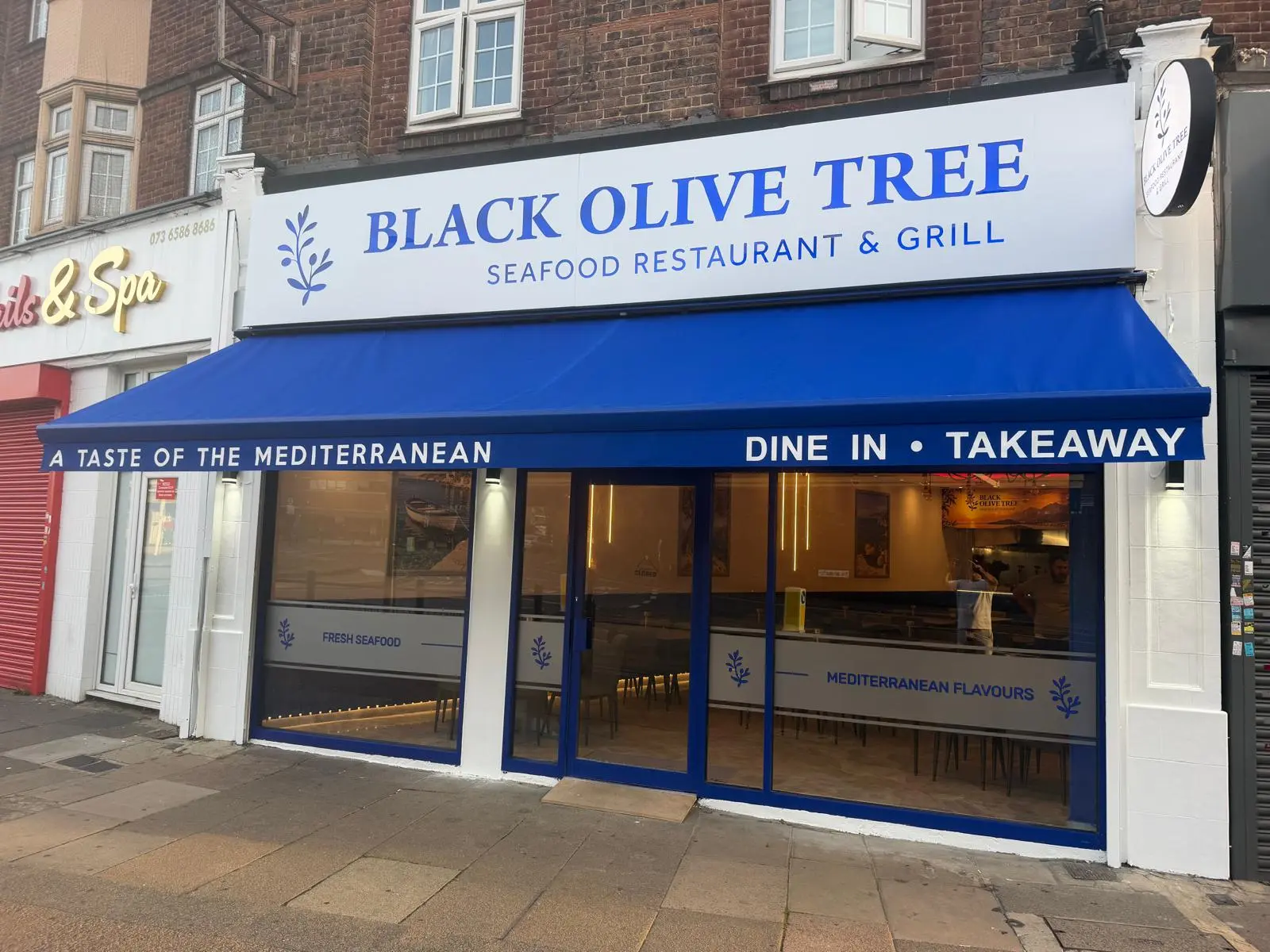 Black Olive Tree storefront on The Broadway, Southgate — blue awning reading A Taste of the Mediterranean